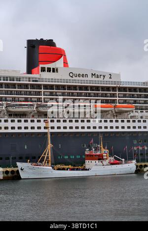 La storica nave turistica MS Polarstar ormeggiata accanto al transatlantico Cunard Queen Mary 2 ad Alesund nella Norvegia occidentale. Foto Stock