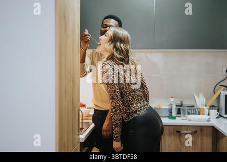 Uomo e donna che si godono un momento di gioco in una cucina moderna Foto Stock