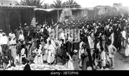 Una scena spesso testimoniata nelle strade della città . Un battaglione di fanteria britannico in marcia lungo una delle principali arterie affollate di arabi e altri nativi, e residenti di Baghdad 1917 Foto Stock