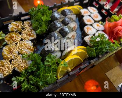 Panini di sushi ordinati in un vassoio speciale, pronti per essere serviti - una presentazione elegante e appetitosa della cucina giapponese. Foto Stock