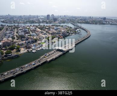Vista aerea di un fiume tortuoso che riflette la luce del sole in un paesaggio urbano densamente popolato, Lekki fase 1, Lekki, Lagos, Nigeria. Foto Stock