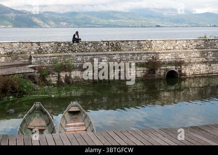 3 ottobre 2019, Ioannina, Epiro, Grecia: Una donna siede su una riva del lago Pamvotis o lago Ioannina. Ioannina è la capitale e la città più grande dell'unità regionale di Ioannina e dell'Epiro, una regione amministrativa nel nord-ovest della Grecia. (Immagine di credito: © Nir Alon/ZUMA Wire) Foto Stock