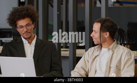 Due uomini d'affari multirazziali uomini d'affari afroamericani partner diversi colleghi maschi discutono online dei dati di Internet analizzando il progetto di marketing Foto Stock