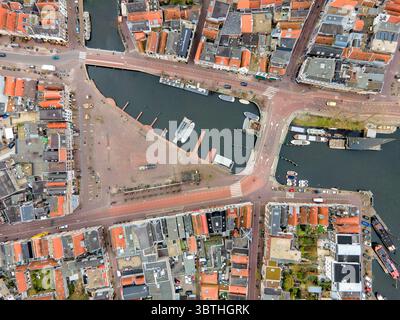 Vista aerea delle barche che riposano nel porto, circondato da edifici con tetti arancioni e strade lastricate di mattoni, Almere, Flevoland, Paesi Bassi. Foto Stock