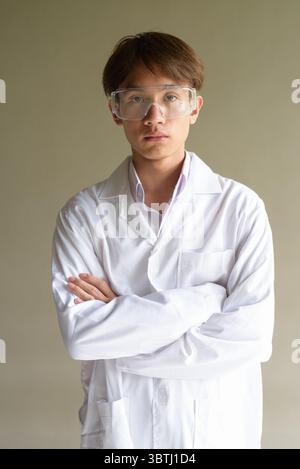 Giovane scienziato asiatico studente ricercatore che indossa camice da laboratorio Foto Stock