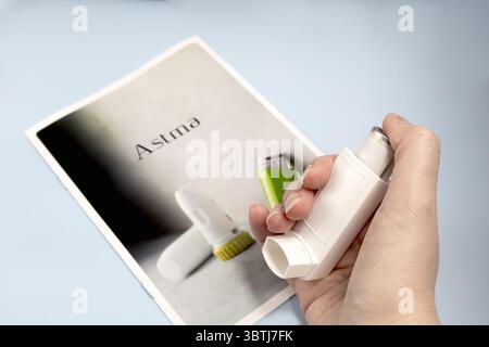 Mano femminile che tiene in mano farmaci per l'asma inalatore. Foto di alta qualità Foto Stock