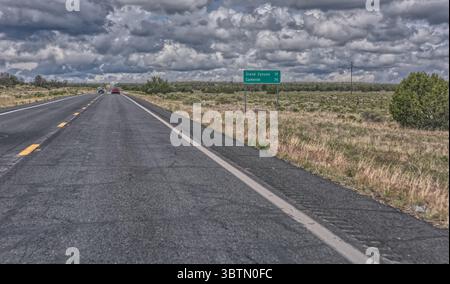 Auto che guidano lungo la US Route 64 e superano un cartello del Grand Canyon in un giorno coperto, Arizona, Stati Uniti Foto Stock