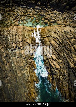 Vista aerea delle aspre scogliere che abbracciano il mare turchese, dove le onde bianche schiumose si infrangono contro le rocce, Sugarloaf Rock, Australia Occidentale, Australia. Foto Stock