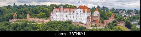 Vista aerea ravvicinata del castello di Landshut Trausnitz con mura bianche, torri in mattoni e bandiera bavarese in Germania Foto Stock