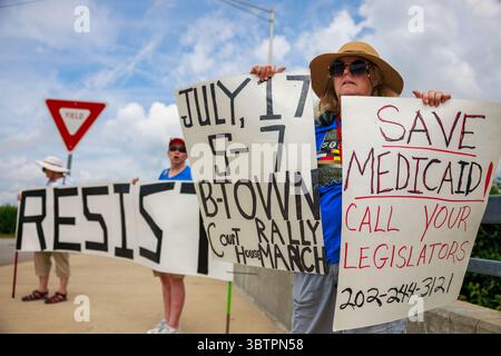 BLOOMINGTON, INDIANA - 15 LUGLIO: I membri del 50501, un movimento progressista di base che si oppone alla seconda amministrazione Trump, stanno vicino all'ingresso di West Third Street all'i-69 durante una protesta pop-up il 15 luglio 2025, a Bloomington, Ind. Il gruppo stava promuovendo la prossima marcia e manifestazione "People Have the Power", prevista per il 17 luglio dalle 5-7 al tribunale della contea di Monroe, co-ospitato da Bloomington 50501, il NAACP Monroe County Branch, l'Università per la giustizia razziale e la Lega delle donne votanti della Contea di Bloomington-Monroe. Crediti: Jeremy Hogan/Alamy Live News Foto Stock