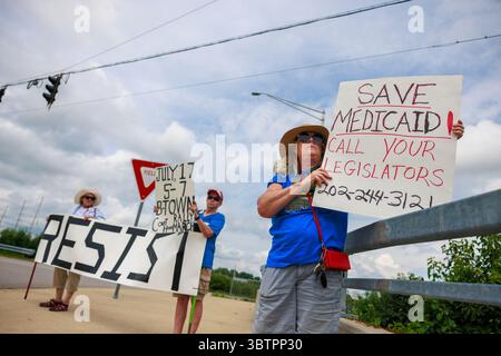 BLOOMINGTON, INDIANA - 15 LUGLIO: I membri del 50501, un movimento progressista di base che si oppone alla seconda amministrazione Trump, stanno vicino all'ingresso di West Third Street all'i-69 durante una protesta pop-up il 15 luglio 2025, a Bloomington, Ind. Il gruppo stava promuovendo la prossima marcia e manifestazione "People Have the Power", prevista per il 17 luglio dalle 5-7 al tribunale della contea di Monroe, co-ospitato da Bloomington 50501, il NAACP Monroe County Branch, l'Università per la giustizia razziale e la Lega delle donne votanti della Contea di Bloomington-Monroe. Crediti: Jeremy Hogan/Alamy Live News Foto Stock