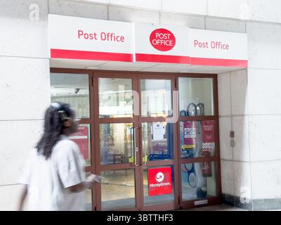 Segnaletica dell'ufficio postale in rosso su sfondo bianco sopra l'ingresso del negozio Foto Stock