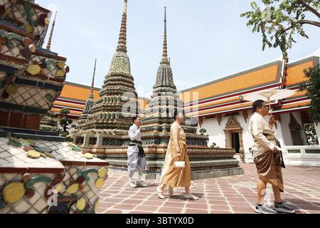 Bangkok, Thailandia. 15 luglio 2025. I turisti in costumi tradizionali tailandesi visitano il tempio Wat Pho a Bangkok, Thailandia, 15 luglio 2025. Il tempio Wat Pho è uno dei più magnifici complessi di templi buddisti di Bangkok. Crediti: Rachen Sageamsak/Xinhua/Alamy Live News Foto Stock