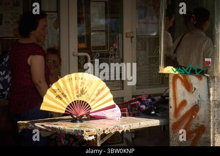 Bucarest, Romania. 15 luglio 2025: Il venditore ambulante vende fan a mano in uno stallo improvvisato nel centro di Bucarest, mentre un'ondata di caldo colpisce la Romania. Crediti: Lucian Alecu/Alamy Live News Foto Stock