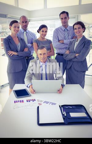 Design piatto che mostra sei professionisti intorno a un tavolo bianco con laptop e carte in un ufficio alto Foto Stock