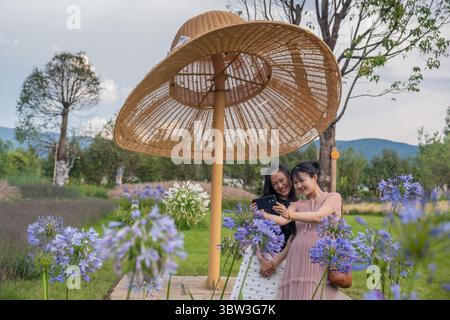 Kunming, la provincia cinese dello Yunnan. 15 luglio 2025. I turisti posano per le foto in un parco sul lago nella Prefettura autonoma di Dali Bai, nella provincia dello Yunnan, nel sud-ovest della Cina, 15 luglio 2025. Conosciuta per la sua incredibile bellezza naturalistica, la provincia dello Yunnan ha coltivato un'industria turistica estiva, offrendo ai turisti esperienze diverse tra foreste, montagne innevate, paludi e campi di fiori. Crediti: Luo Xincai/Xinhua/Alamy Live News Foto Stock
