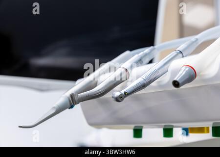 Vista ravvicinata degli strumenti odontoiatrici su uno sgabello operatore in una moderna clinica odontoiatrica, che mostra gli strumenti di precisione utilizzati per varie procedure odontoiatriche e. Foto Stock