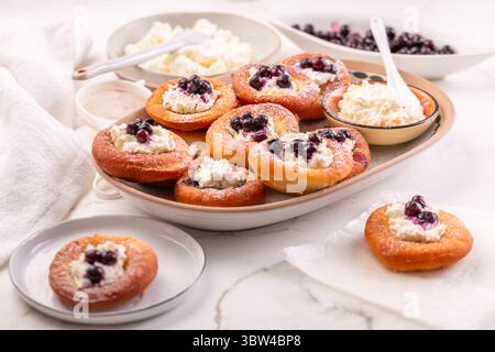 Dolci fritti (vdolky) di pasta lievitata, ciambelle, pasticceria, ripieni di formaggio spalmabile Foto Stock