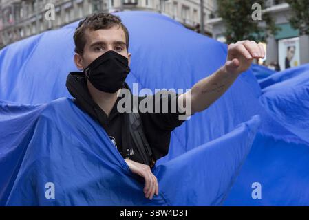 2 novembre 2020, Madrid, Spagna: Un attivista che indossa una maschera facciale viene visto all'interno del panno blu durante la manifestazione..durante la terza ribellione internazionale, il movimento Extinction Rebellion ha bloccato la Gran VÃ­a Street a Madrid per protestare contro le conseguenze dell'innalzamento del livello del mare. Il movimento, trasportando un panno blu di 150 metri quadrati da piazza Callao a piazza Spagna, marcia attraverso la Gran VÃ­a Street per rendere visibile il crescente numero di persone colpite dall'aumento del livello del mare, causato dai cambiamenti climatici. Questo atto, sotto il nome di "affondamento", ha rappresentato l'enorme numero di morti dovuti Foto Stock