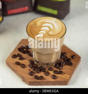 Caffè latte in vetro alto con chicchi di caffè Foto Stock