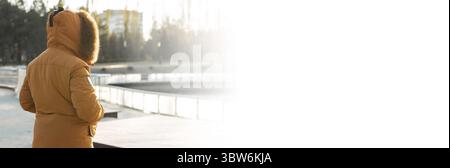 Banner inverno in arrivo, uomo che indossa la giacca invernale vista posteriore su sfondo parco freddo con spazio per le copie e posto per il testo. Concetto di stagione e persone Foto Stock