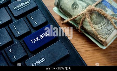 Pulsante fattura fiscale sulla tastiera con Rolled Money Foto Stock