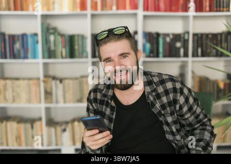 Un bell'uomo sorridente che si rilassa a casa. Gen Z e concetto di generazione millenaria Foto Stock