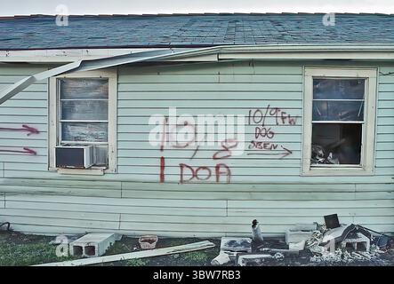 New Orleans, LOUISIANA, USA - 2006: Casa distrutta con segni lasciati dai soccorritori il 9 ottobre 2005 che mostrano 1 persona morta all'arrivo (DOA) e un cane visto, e detriti lasciati dalla corsa d'acqua dalla breccia del canale industriale Levee nel Lower Ninth Ward dopo l'uragano Katrina Foto Stock