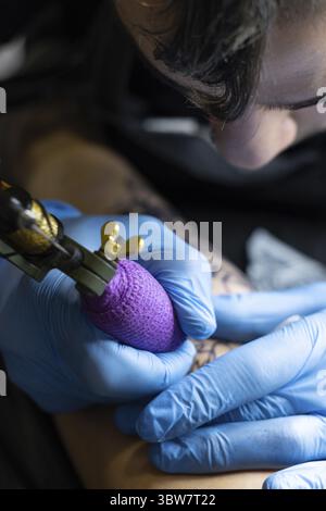 Primo piano verticale di un tatuatore irriconoscibile. Soria, Castilla y Leon, Spagna Foto Stock