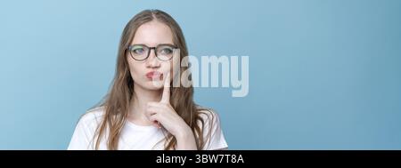 Preoccupata stupida e insicura giovane donna con capelli lunghi dita nervose in allarme Foto Stock