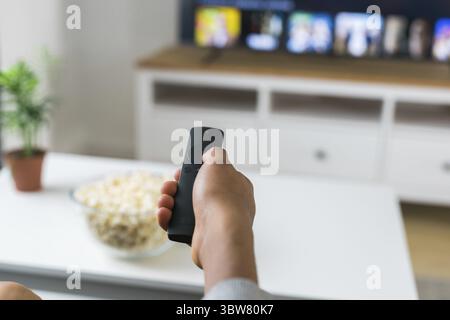 Die Fernbedienung ist auf den Fernsehbildschirm gerichtet, zur Steuerung und Auswahl der Fernsehunterhaltung. Konzept fuer TV, Serien und Streamingdie Foto Stock