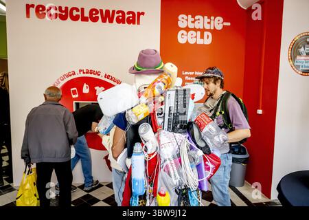 L'AIA - le persone consegnano bottiglie di plastica al negozio di riciclaggio Droppie. L'azienda paga i consumatori per i rifiuti adeguatamente separati: Tessili, rifiuti elettronici, oli, materie plastiche e lattine. Droppie vuole quindi vendere questo flusso "pulito" di rifiuti alle aziende che lavorano o riciclano rifiuti. ANP /HOLLANDSE HOOGTE /ROBIN UTRECHT paesi bassi uscita - belgio uscita Foto Stock