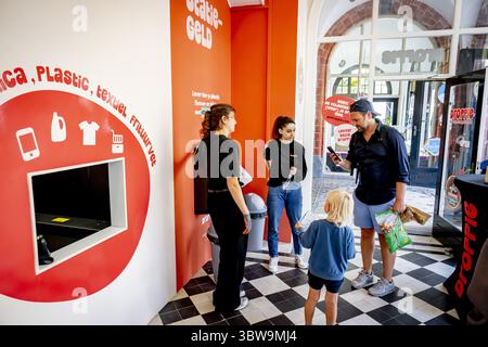L'AIA - le persone consegnano bottiglie di plastica al negozio di riciclaggio Droppie. L'azienda paga i consumatori per i rifiuti adeguatamente separati: Tessili, rifiuti elettronici, oli, materie plastiche e lattine. Droppie vuole quindi vendere questo flusso "pulito" di rifiuti alle aziende che lavorano o riciclano rifiuti. ANP /HOLLANDSE HOOGTE /ROBIN UTRECHT paesi bassi uscita - belgio uscita Foto Stock