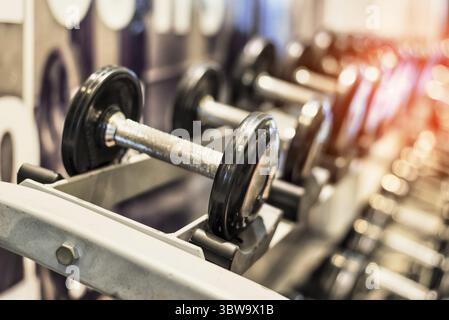 Close up nero metallizzato con manubri in acciaio set. Manubri su rack in sport fitness center. Formazione di allenamento e palestra per il fitness concetto. Salute e benessere b Foto Stock