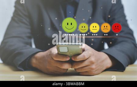 Concetto di servizio clienti e soddisfazione, uomo d'affari che preme emoticon Smiley Face sul touch screen virtuale, icona Happy Smiley Face per dare soddisfazione Foto Stock