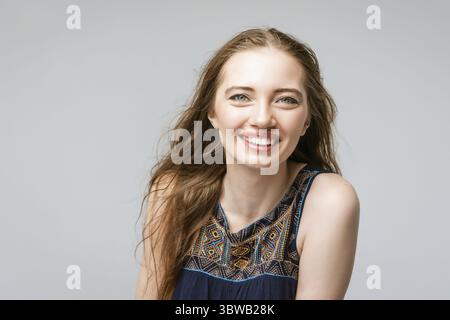 Ritratti affascinante giovane donna in abiti neri sorridente ampiamente con denti bianchi Foto Stock