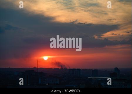 Tramonto colorato con spettacolari nuvole sullo skyline di Dnipro, Ucraina, fotografato da un alto punto panoramico. Edifici sagomati. Grandangolo vi Foto Stock