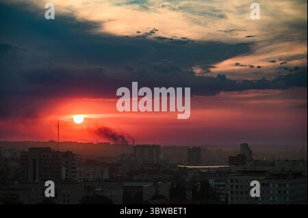 Tramonto colorato con spettacolari nuvole sullo skyline di Dnipro, Ucraina, fotografato da un alto punto panoramico. Edifici sagomati. Grandangolo vi Foto Stock