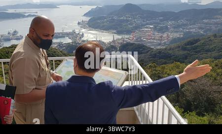 24 novembre 2020 - Sasebo, Nagasaki, Giappone - il capitano David Adams, comandante delle attività della flotta Sasebo, ascolta il sindaco della città di Sasebo Norio Tomonaga che indica le aree di interesse locali da una vista sul Monte Yumihari a Sasebo, Giappone, 24 novembre 2020. Adams e Tomonoga si incontrano periodicamente per discutere questioni che riguardano sia la CFAS che la città di Sasebo e per mantenere una discussione aperta e promuovere la reciproca buona volontà. (Immagine di credito: © U.S. Navy/ZUMA Wire/ZUMAPRESS.com) Foto Stock