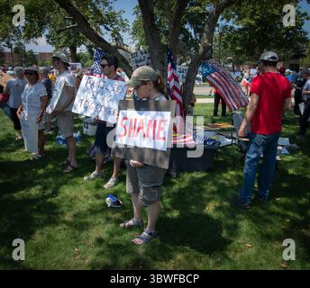 Burlington, Massachusetts, Stati Uniti. 16 luglio 2025. 13a manifestazione settimanale «testimoniare» al di fuori della struttura del New England per l’immigrazione e l’applicazione delle dogane (ICE) a Burlington. La struttura, 26 km a nord-ovest di Boston, ospita persone detenute dal GHIACCIO negli stati di Rhode Island, Connecticut, Massachusetts, New Hampshire, Maine e Vermont. Centinaia di persone hanno partecipato alla manifestazione pacifica contro L'ICE, Donald Trump e la sua attuale amministrazione al di fuori della struttura. Dimostratori all'ombra. Crediti: Chuck Nacke / Alamy Live News Foto Stock