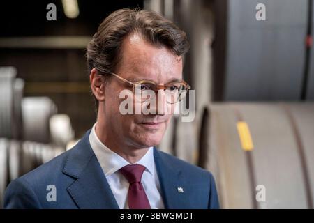 NRW-Ministerpräsident Hendrik Wüst besucht Niedax Group. Im Bild Nordrhein-Westfalens Ministerpräsident Hendrik Wüst vor Stahlrollen. Wüst besichtigte das Niedax-Tochterunternehmen Bandstahl-Service-Hagen und wurde dort vom CEO der Niedax-Group Bruno Reufels über die Rolle des Unternehmens beim Ausbau des Glasfasernetzes in Deutschland informiert. Hagen Nordrhein-Westfalen Deutschland *** il ministro dell'NRW Hendrik Wüst visita il gruppo Niedax nella foto Renania settentrionale-Westphalias il ministro presidente Hendrik Wüst davanti ai rotoli di acciaio Wüst ha visitato la controllata Niedax Bandstahl Service Hage Foto Stock