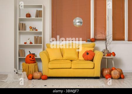 Elegante soggiorno con ballo da discoteca e divano giallo decorato per la festa di Halloween Foto Stock