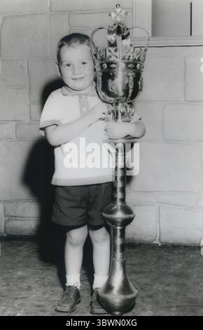 19 ottobre 1957 - Jamestown, Virginia, Stati Uniti - Uno dei momenti salienti del Festival è l'Old World Pavilion in cui il governo britannico ha allestito una grande mostra. Racconta la storia degli inizi di Jamestown e la storia della colonizzazione britannica. CHRISTOPHER BUTTS, di quattro anni, di Westfield, New Jersey, dimostra che la replica della Mace dello Speaker, simbolo dell'autorità della camera dei comuni britannica, è più grande di lui. Risalente al 1660, la Mercia dello Speaker è portata dal Sergente d'armi in processione prima dell'apertura di ogni sessione dei comuni. Si appoggia su un tavolo durante la sessione Foto Stock