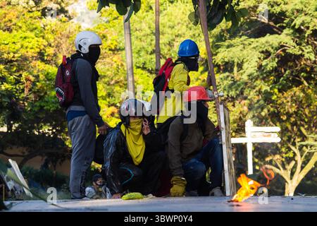 28 giugno 2021, Medellin, Antioquia, Colombia: I demosntratori in prima linea si coprono dietro una porta e scudi artigianali mentre le proteste anti-governative si sollevano in scontri tra i manifestanti e la polizia antisommossa colombiana (ESMAD), tra tensioni politiche contro il governo del presidente Ivan Duque, casi di brutalità della polizia e disuguaglianze mentre la Colombia segna un secondo mese di proteste anti-governative, a Medellin, Antioquia - Colombia il 28 giugno 2021. (Immagine di credito: © Jessica Patino/LongVisual tramite ZUMA Wire) Foto Stock