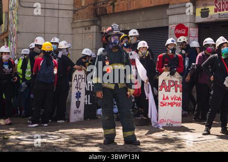 28 giugno 2021, Medellin, Antioquia, Colombia: Un vigile del fuoco si trova di fronte ai manifestanti in prima linea mentre le proteste anti-governative si sviluppano in scontri tra manifestanti e la polizia antisommossa colombiana (ESMAD), tra tensioni politiche contro il governo del presidente Ivan Duque, casi di brutalità della polizia e disuguaglianze mentre la Colombia segna un secondo mese di proteste anti-governative, a Medellin, Antioquia - Colombia il 28 giugno 2021. (Immagine di credito: © Jessica Patino/LongVisual tramite ZUMA Wire) Foto Stock