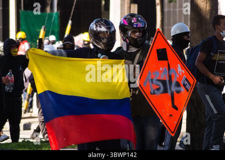 28 giugno 2021, Medellin, Antioquia, Colombia: Due manifestanti detengono una bandiera colombiana mentre le proteste anti-governative si sviluppano in scontri tra i manifestanti e la polizia antisommossa colombiana (ESMAD), tra tensioni politiche contro il governo del presidente Ivan Duque, casi di brutalità della polizia e disuguaglianze, mentre la Colombia segna un secondo mese di proteste anti-governative, a Medellin, Antioquia, Colombia, il 28 giugno 2021. (Immagine di credito: © Jessica Patino/LongVisual tramite ZUMA Wire) Foto Stock