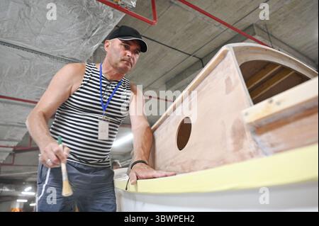 Un uomo lavora su uno yacht presso l'UNBROKEN Center di Leopoli, Ucraina, 16 luglio 2025. Più di 30 pazienti hanno costruito lo yacht da febbraio. Si prevede che la nave sarà varata tra un mese. (Foto di Anastasiia Smolienko/Ukrinform) Foto Stock