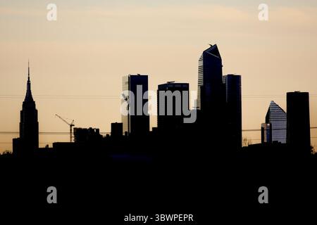 Lo skyline di Manhattan si illumina di fronte a un cielo color pastello al tramonto mentre cala la sera sul fiume Hudson, rivelando l'iconica silhouette di New York al crepuscolo!!! Foto Stock
