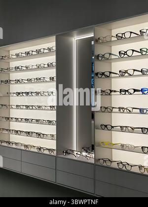 San Pietroburgo, Russia - 07.12.2025. Gli occhiali sono ordinatamente organizzati sugli scaffali in un elegante negozio ottico. Sono mostrate più paia di occhiali da vista Foto Stock