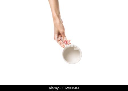 Le mani femminili tengono una tazza in ceramica bianca su sfondo bianco. Mani femminili con una manicure rossa fresca. Isolato su sfondo bianco. Foto Stock